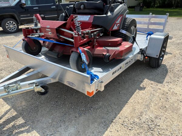 An all aluminum trailer loaded with a zero turn lawn mower.
