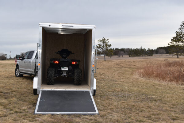 An ATV parked inside an enclosed trailer.
