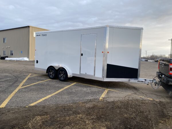 A tandem axle white enclosed trailer in a parking lot.